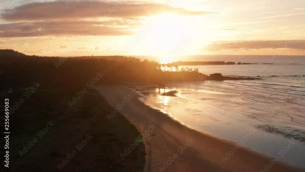Drone descending over Bastendorff Beach near Coos Bay Oregon, showing Cape Arago lighthouse in the background as a silhouette Drone descending over Bastendorff Beach near Coos Bay Oregon, showing Cape Arago lighthouse in the background as a silhouette