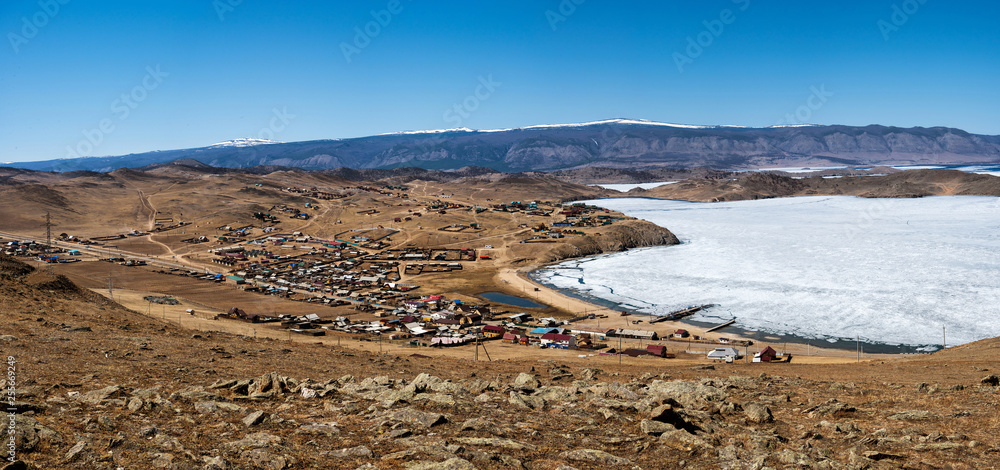 View of spring landscape in Siberia with part of frozen lake Baikal in the distance from the top view.