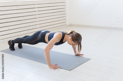 People  sport and fitness concept - young beautiful sportswoman doing push ups