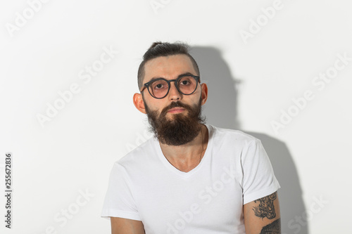 Beauty, fashion and people concept - Hipster man with beard posing over white background © satura_