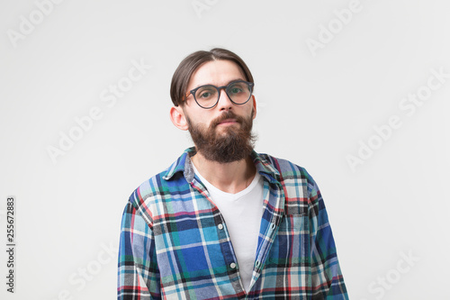 Portrait of a young bearded hipster stylish guy over white background. © satura_
