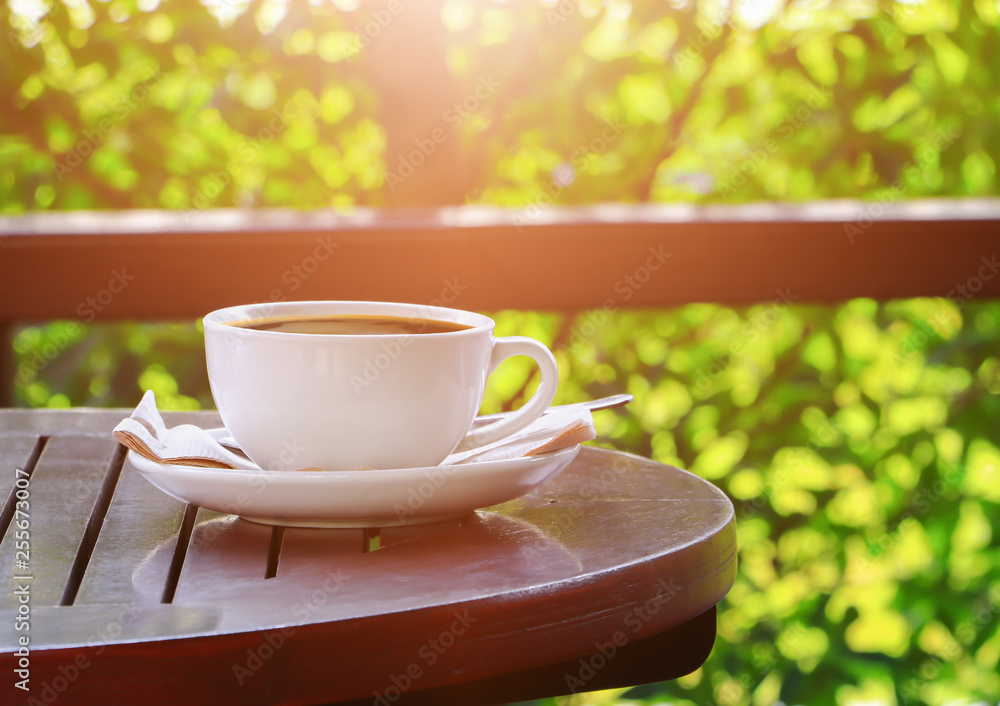 black coffee in cup white on table wood floor background in morning black coffee in cup white on table wood floor background in morning