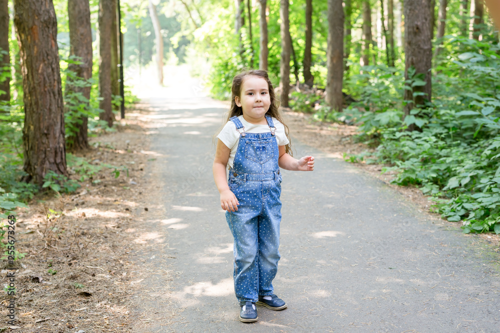 Children, childhood and nature concept - Portrait of beautiful small baby girl playing in the park