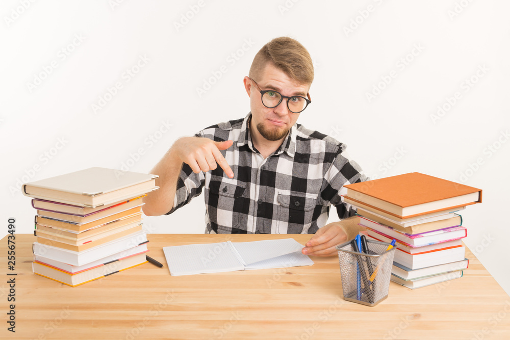 Knowledge, student and education concept - Guy sits at the table and makes notes in a notebook Knowledge, student and education concept - Guy sits at the table and makes notes in a notebook