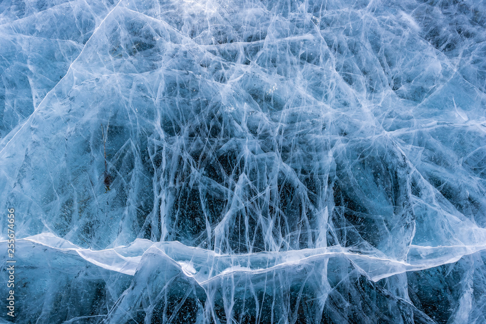 Ice crack texture, Close-up texture surface cracks of the natural ice in frozen water at Baikal lake, Russia. Ice crack texture, Close-up texture surface cracks of the natural ice in frozen water at Baikal lake, Russia.