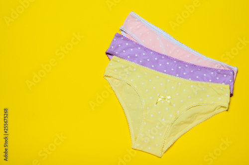 Tableau sur toile Stacked women's panties on a yellow background
