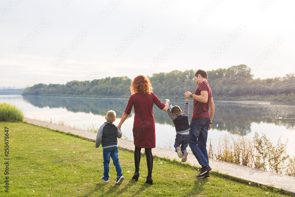 Childhood and nature concept - Family walking by the water Childhood and nature concept - Family walking by the water