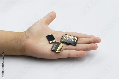 Memory card in kids hand isolated on white background.