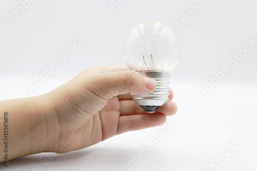 Kids hand holding a light bulb isolated on white background.