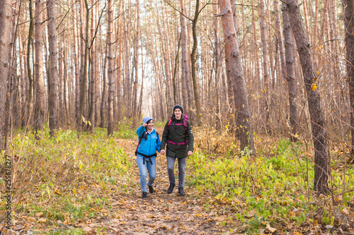 Travel, tourism, hike and people concept - Couple with backpacks walking in the autumn forest © satura_