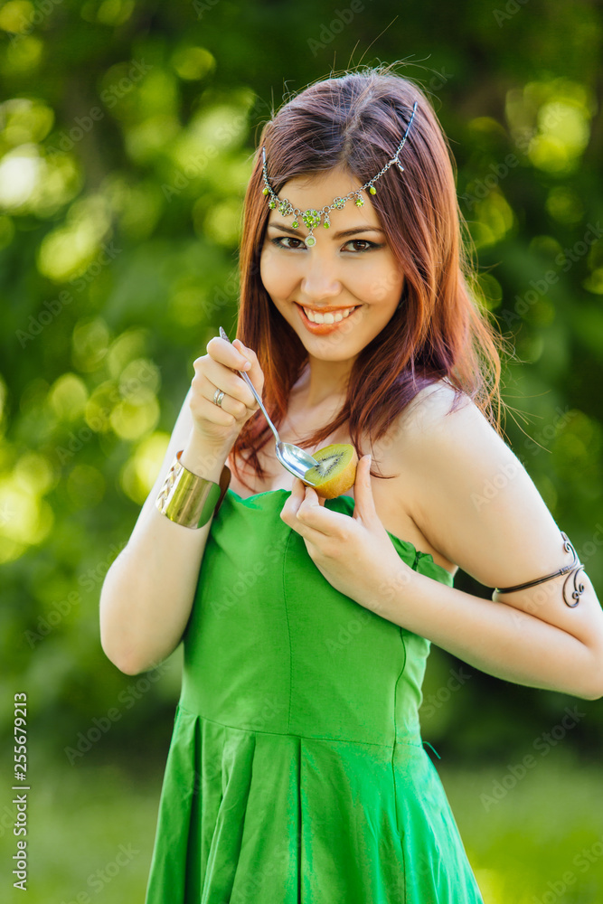 Beautiful young asian woman eating fresh kiwi Beautiful young asian woman eating fresh kiwi
