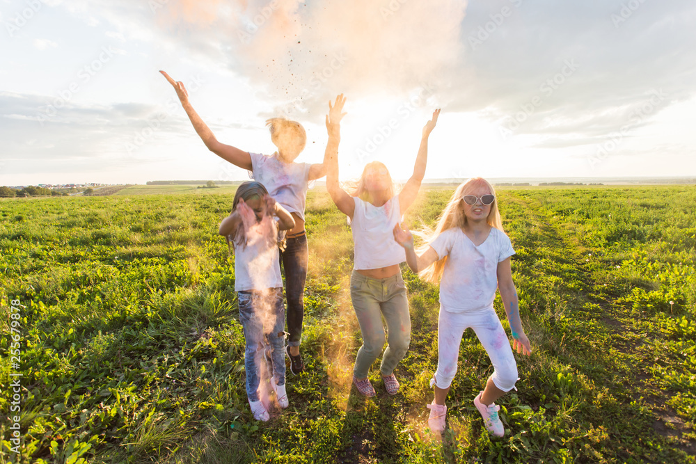 Indian holidays, fun and Holi festival concept - Jumping happy women and girls covered in paint throw up colorful powder Indian holidays, fun and Holi festival concept - Jumping happy women and girls covered in paint throw up colorful powder