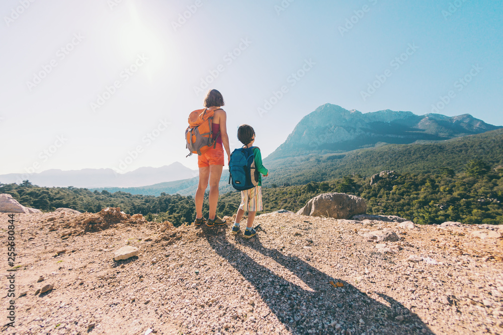 Fototapeta premium Chłopiec i jego matka stoją na szczycie góry.