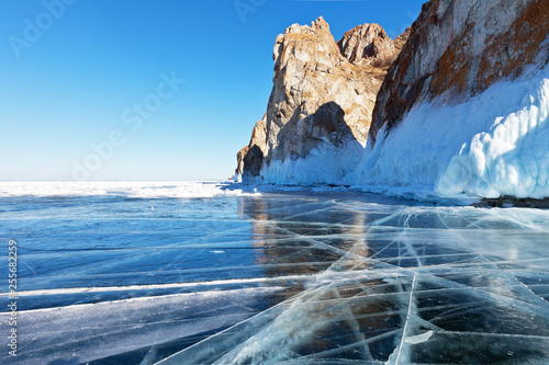 Lake Baikal in the winter season. View from the ice on the cliffs of the Olkhon Island. Winter travel on the ice of a frozen lake