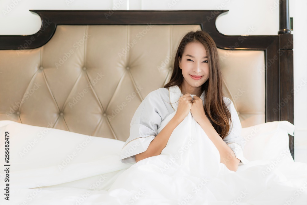 Portrait beautiful young asian woman wake up with happy and smile on bed in bedroom interior Portrait beautiful young asian woman wake up with happy and smile on bed in bedroom interior
