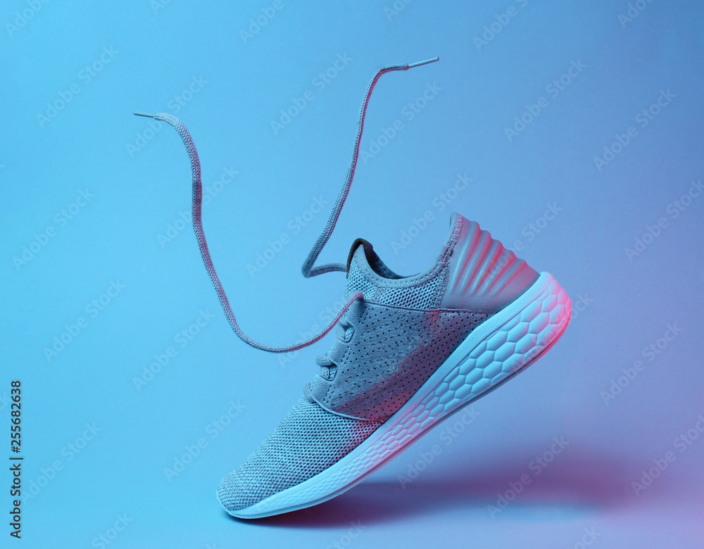 Running sports shoes with flying laces. Neon light Stock Photo | Adobe Stock