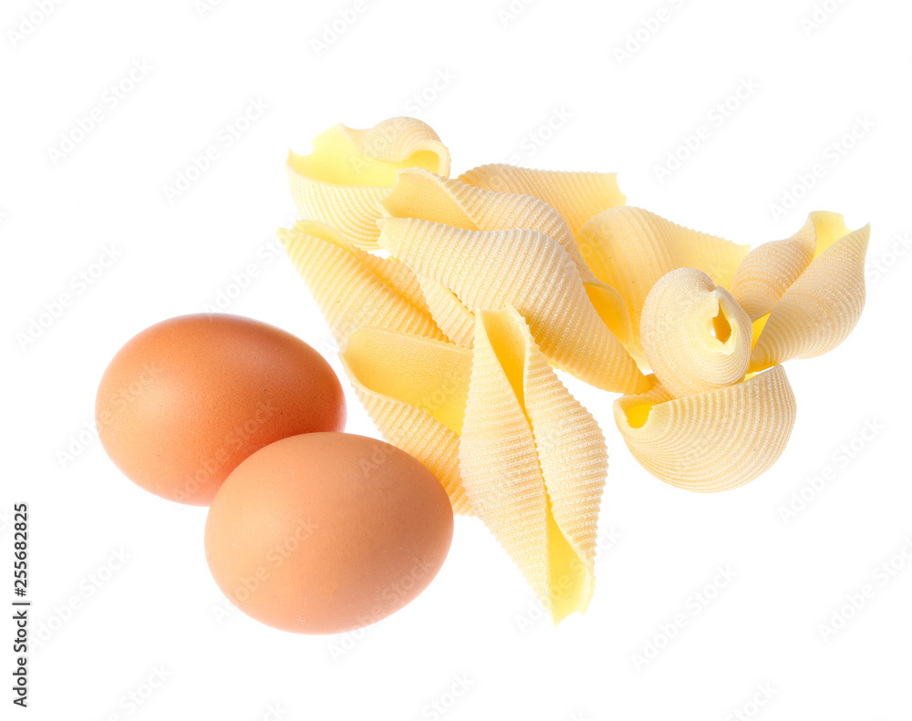 Raw dry conchiglioni, eggs close up isolated on white background Raw dry conchiglioni, eggs close up isolated on white background