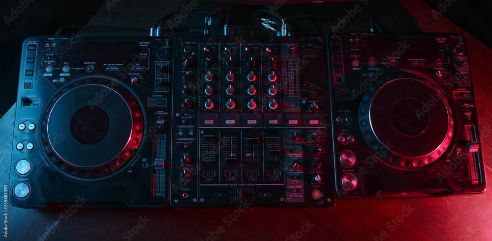 Fototapeta premium Night club, nightlife concept. Disco. DJ remote. Neon light. Top view