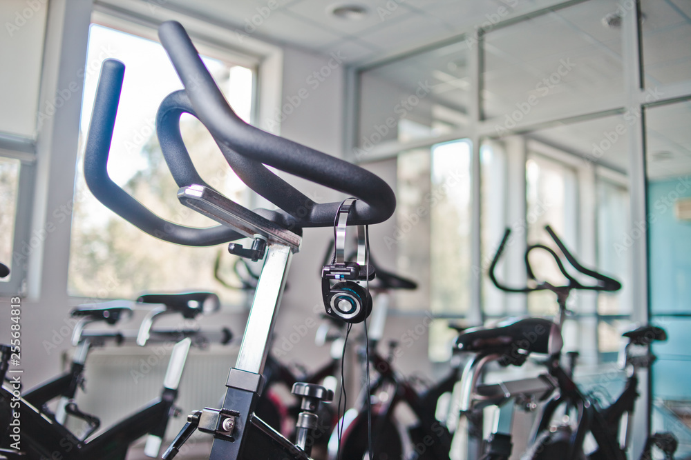 Obraz premium Headphones hanging on a stationary bike at spinning class