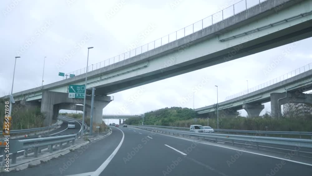 Landscape view of the highway/ express way on the okinawa island in summer daytime from inside the car while moving Landscape view of the highway/ express way on the okinawa island in summer daytime from inside the car while moving