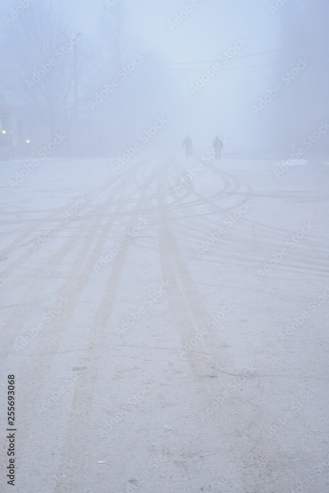 People walking down the road in fog People walking down the road in fog