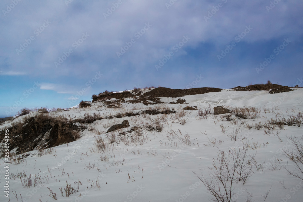 Winter landscape. Rolling hills. Blue sky. Snow. Grunge nature