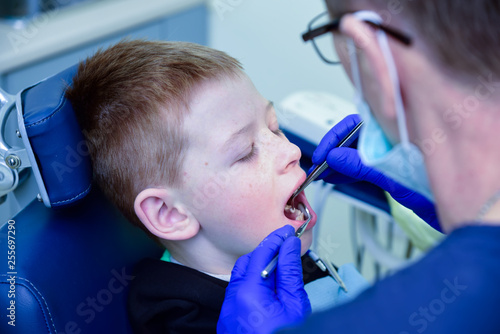 A dentist treats a patient s child in a dental office in a pleasant environment.Dentist  Child  Dental Hygiene