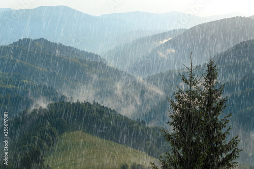 Rain over forest mountains. Misty mountain landscape hills at rainy weather. Rain and sun. photo