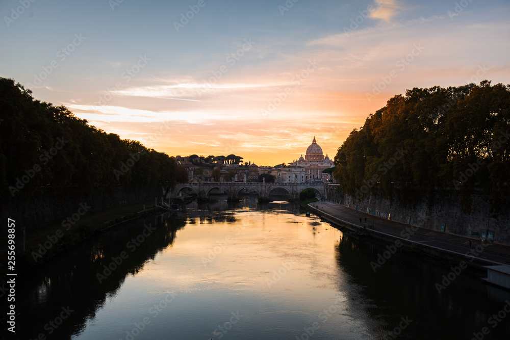 View on the Vatican in Rome, in the Tiber river, Italy, at sunset with dramatic sky. Scenic travel background
