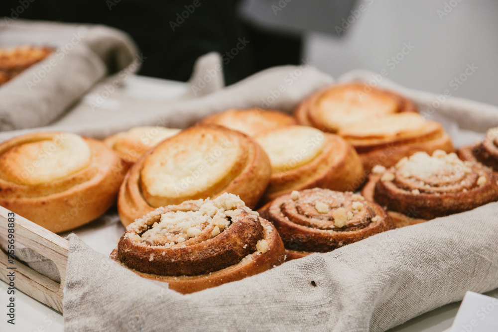 freshly baked cheesecakes and cinnamon rolls in the basket. selective focus