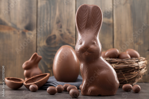 Chocolate Easter bunny, eggs and sweets on rustic background