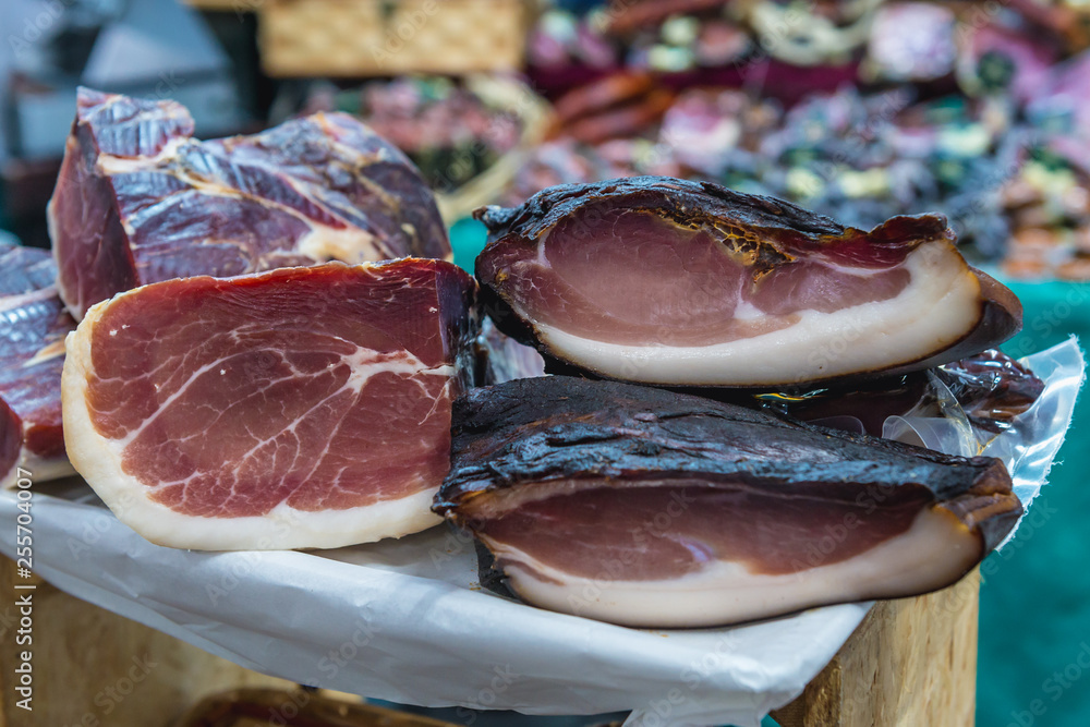 Pieces of ham on Mercado da Baixa food market on Fig tree square in Lisbon city, Portugal