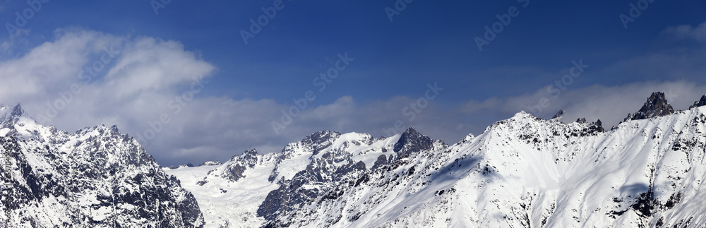 Panorama of snowy mountains at sunny winter day