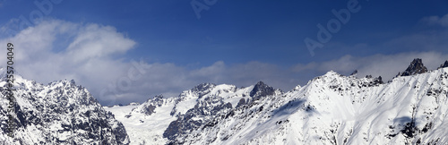 Panorama of snowy mountains at sunny winter day