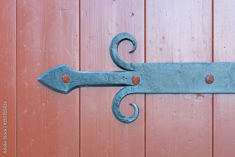 Vintage wrought iron bracket in the form of an arrow to a wooden gate. 19th century