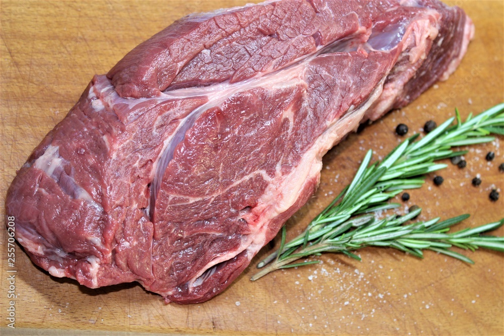  A piece of marbled beef with a sprig of rosemary before cutting