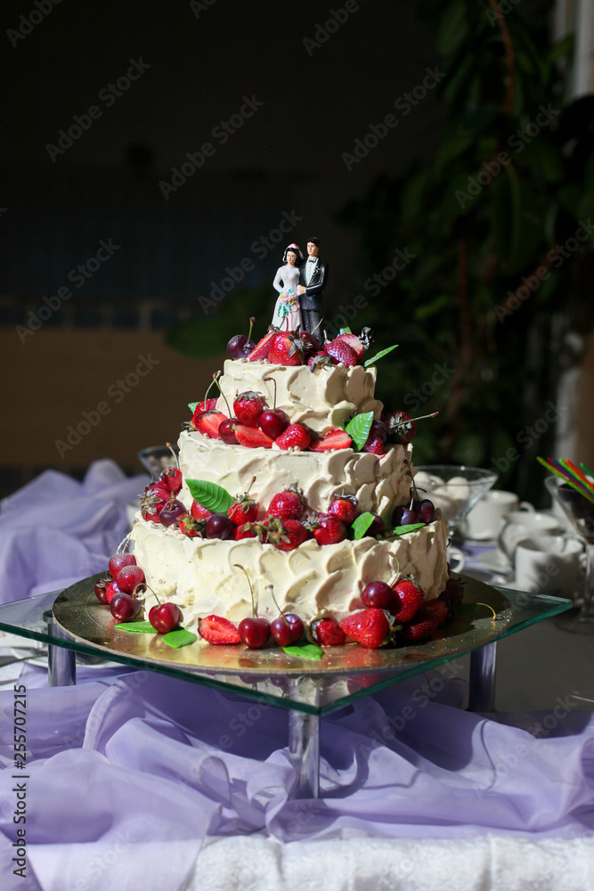 Fototapeta premium Naked wedding cake decorated with berries and flowers