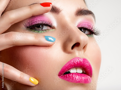 Beautiful fashion woman with a colored nails. Attractive white girl with multicolor manicure.