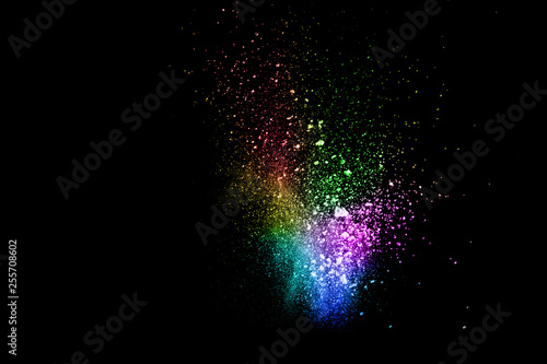 Launched colorful powder on black background.Color powder explosion.Colorful dust splashing. © Pattadis