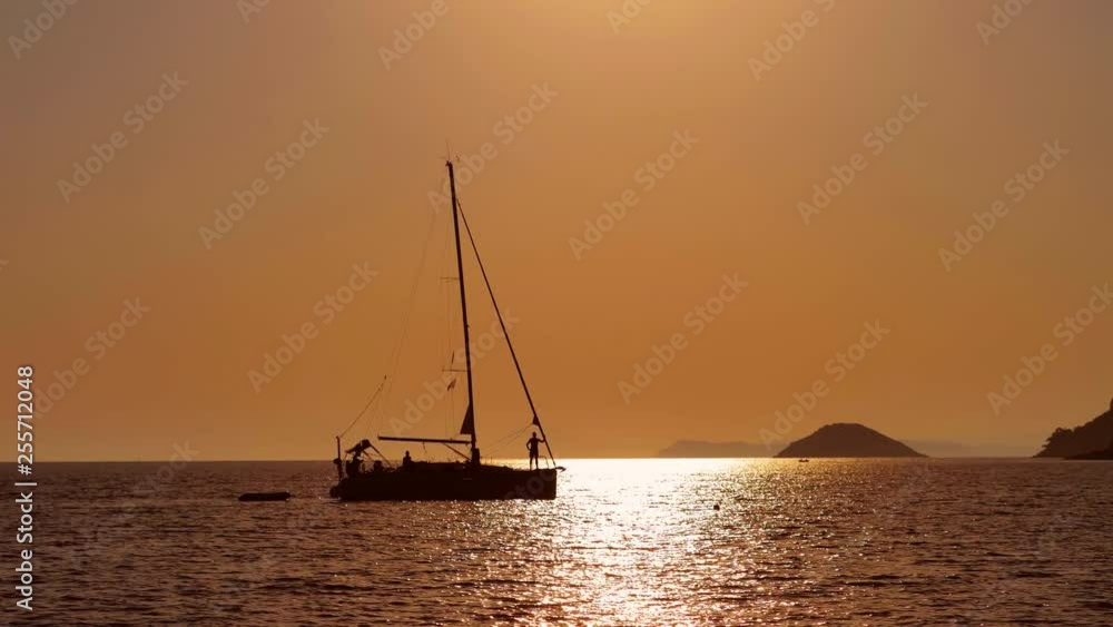 Isolated boat silhouettes go slowly on sea water, beautiful sunset Isolated boat silhouettes go slowly on sea water, beautiful sunset