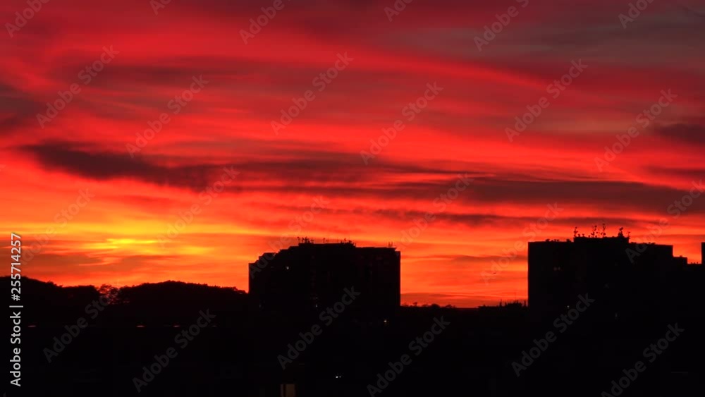 A red sunset over a dark cityscape A red sunset over a dark cityscape