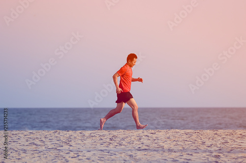 Asian man running on the beach in evening, lifestyle concept.