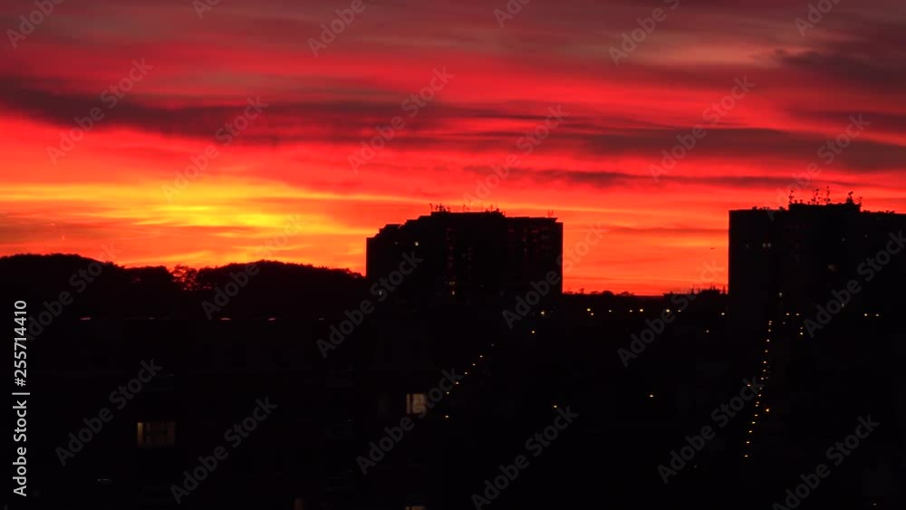 A red sunset over a dark cityscape A red sunset over a dark cityscape