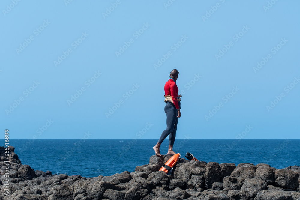 life guard  on top of mountain  / rock