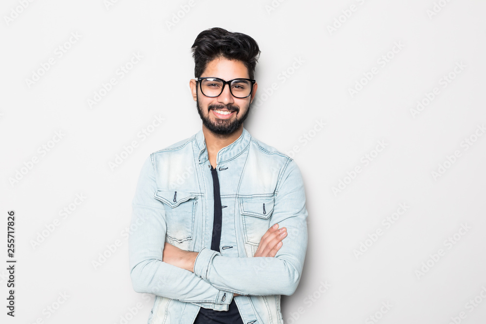 Indian young man in eyesglasses with crossed hands standing over white background Indian young man in eyesglasses with crossed hands standing over white background