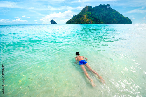 Young boy swim and relax in clear tropical sea