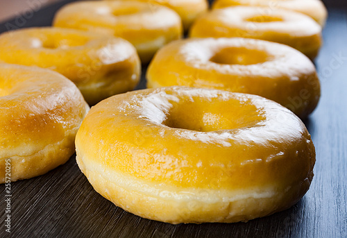DONUTS DE AZÚCAR SOBRE MESA DE MADERA OSCURA