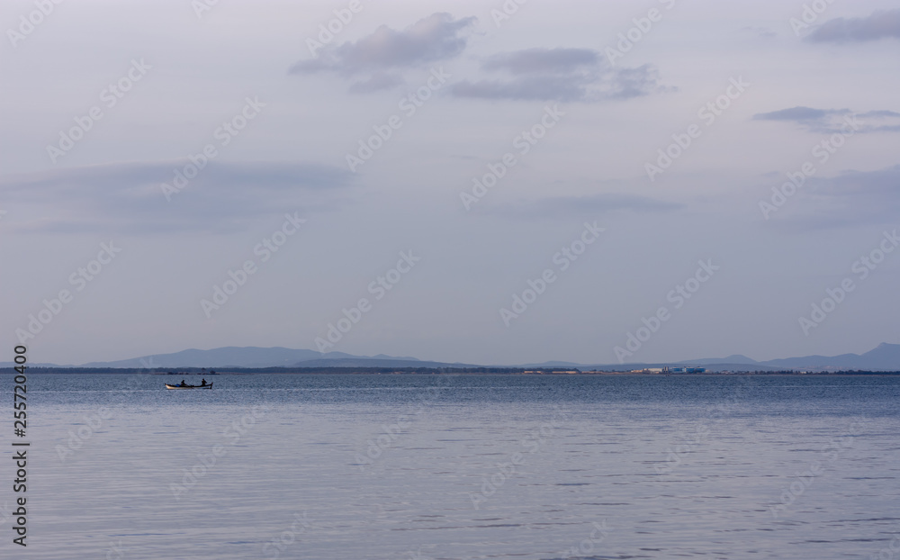 Fishermen on a boat in the sea with moutains in the background, Inciraltı, Izmir, Turkey Fishermen on a boat in the sea with moutains in the background, Inciraltı, Izmir, Turkey