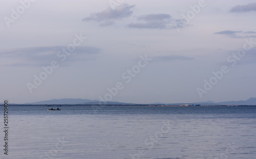 Fishermen on a boat in the sea with moutains in the background, Inciraltı, Izmir, Turkey