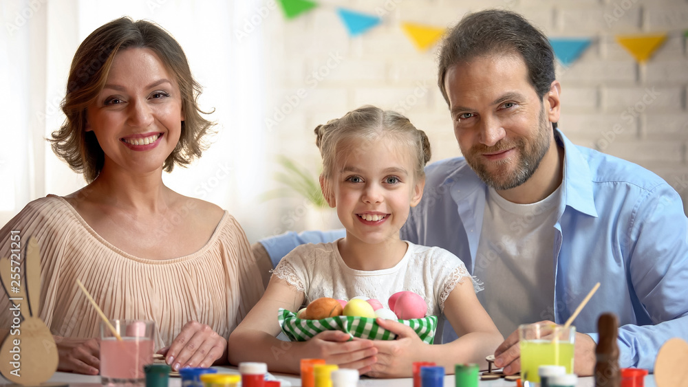 Happy family posing at camera with Easter basket, ancient tradition, celebration Happy family posing at camera with Easter basket, ancient tradition, celebration